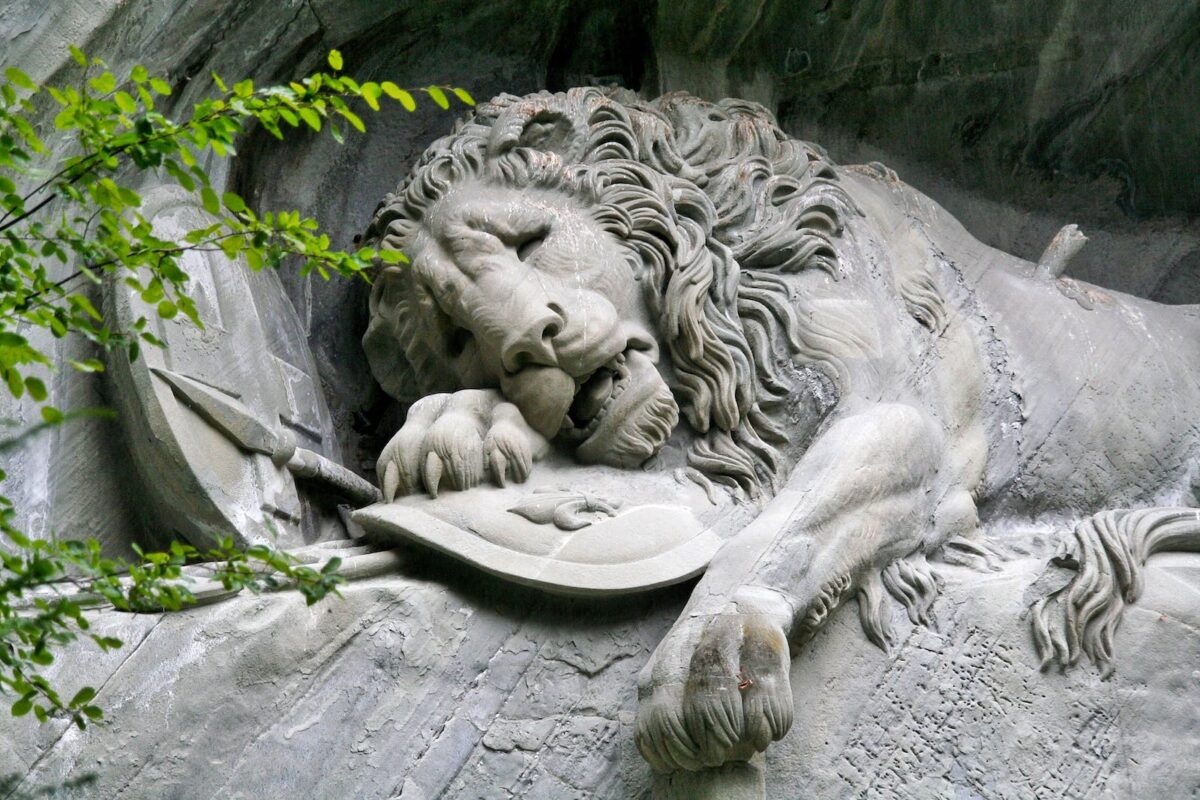 Stone Sculpture of Lion Resting on Rock